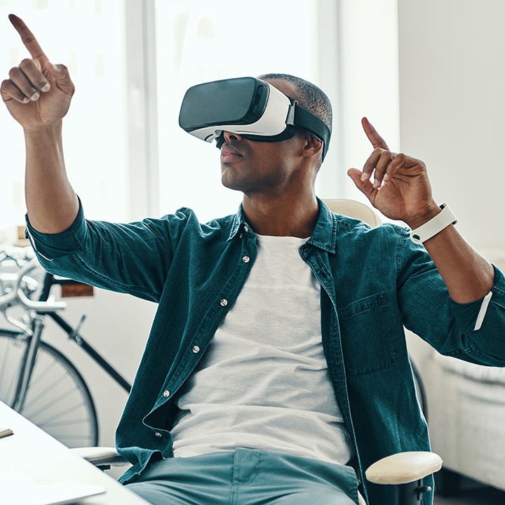 A man wearing a vr headset while pointing to the sky.