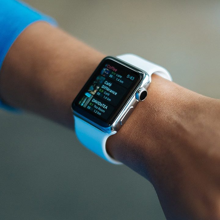 A person wearing an apple watch with white strap.