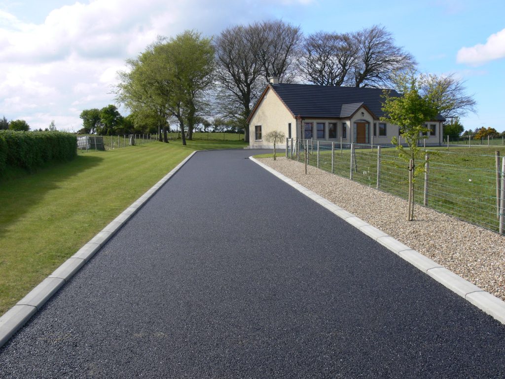 A road with grass and trees on both sides of it