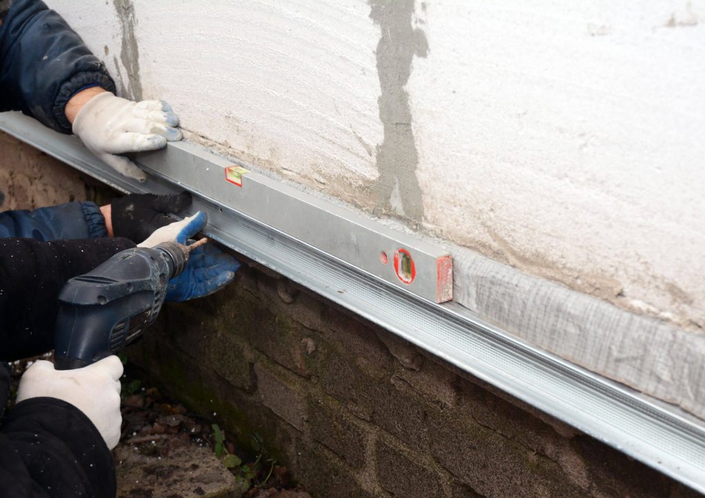 A person is working on the side of a building.