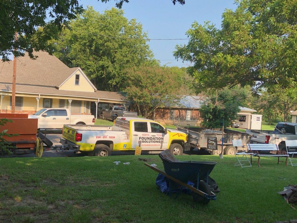 A yard with many vehicles parked in the grass.