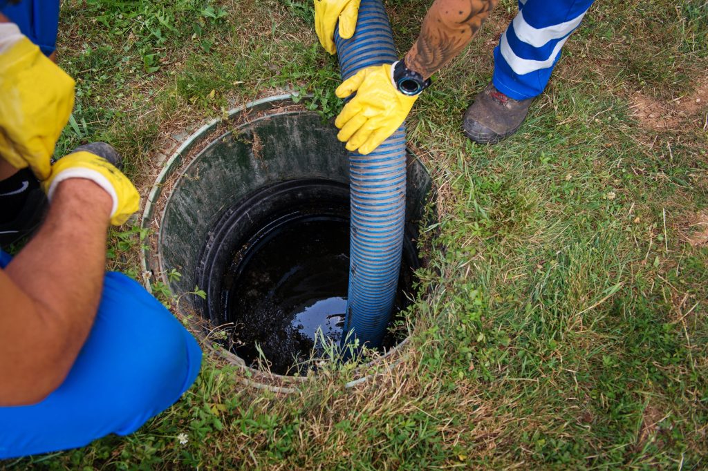 A person in yellow gloves is holding a pipe.