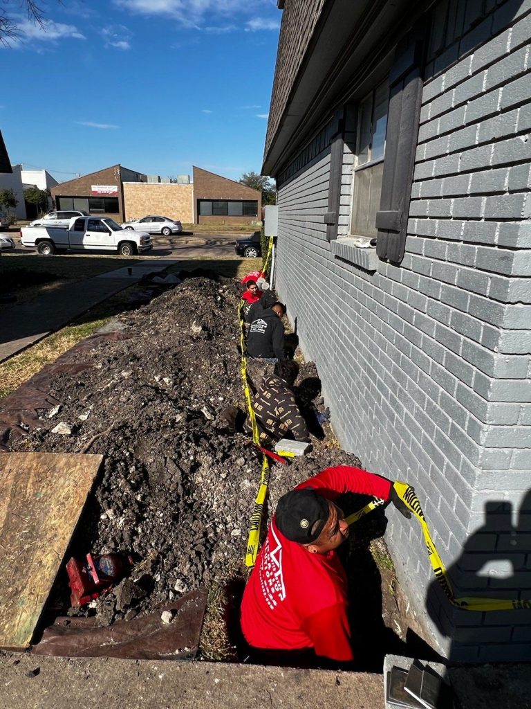 A man in red shirt digging into the ground.