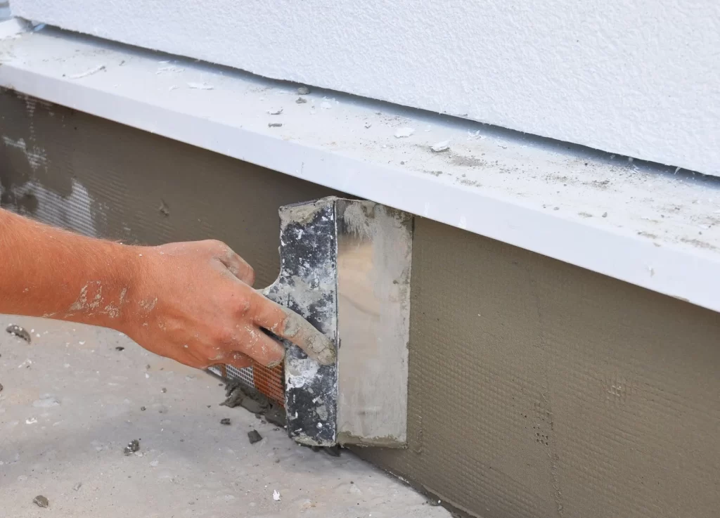 A person is using a spatula to smooth the cement.