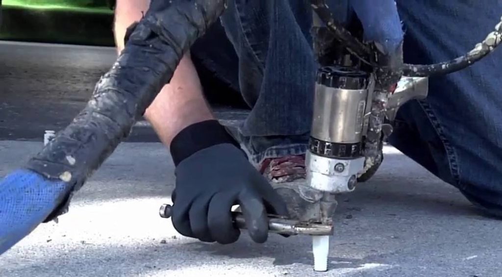 A person with black gloves on working on a machine.